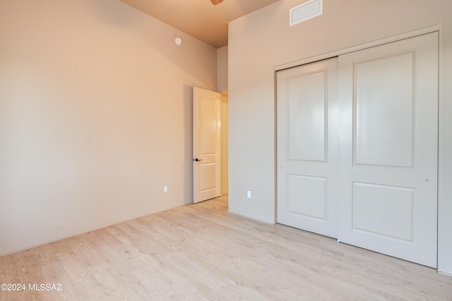 unfurnished bedroom with light hardwood / wood-style floors and a closet