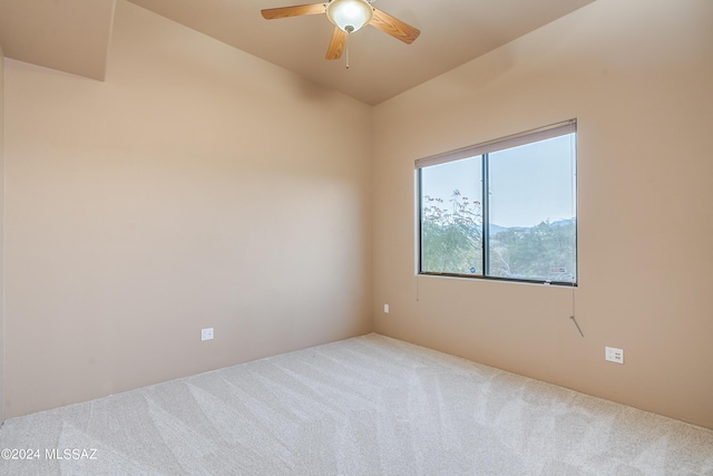 carpeted spare room featuring ceiling fan