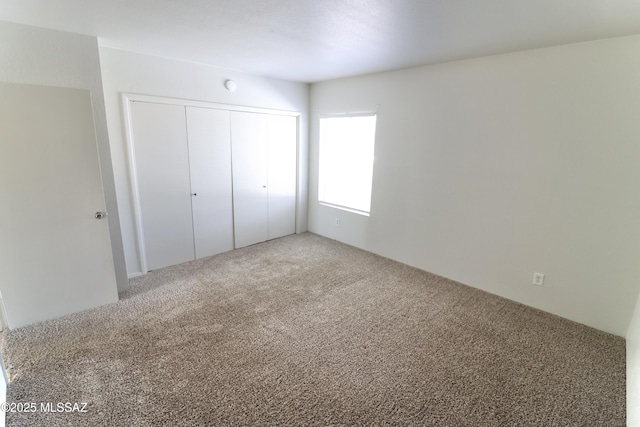 unfurnished bedroom with carpet flooring and a closet