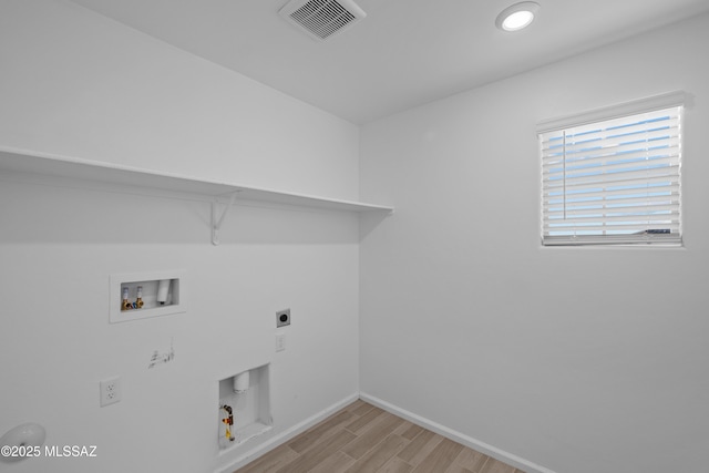 laundry area featuring washer hookup, hookup for an electric dryer, hookup for a gas dryer, and light hardwood / wood-style flooring