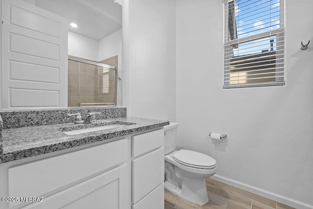 bathroom featuring walk in shower, vanity, toilet, and wood-type flooring