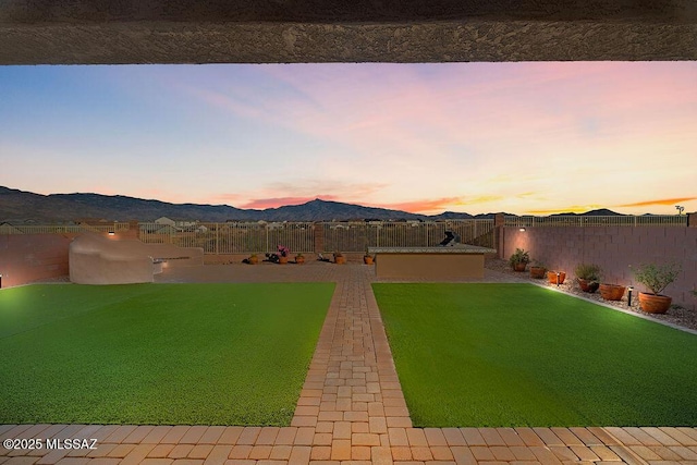 yard at dusk featuring a mountain view