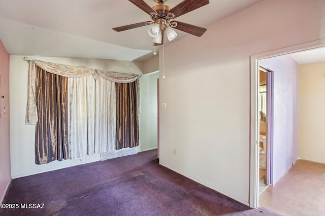 spare room with dark colored carpet and ceiling fan