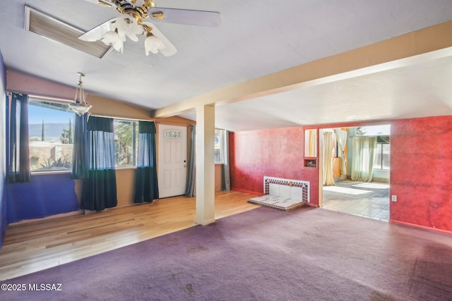 unfurnished living room with a wealth of natural light, light colored carpet, ceiling fan, and vaulted ceiling