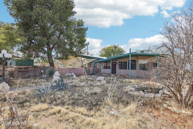 rear view of property with a fire pit