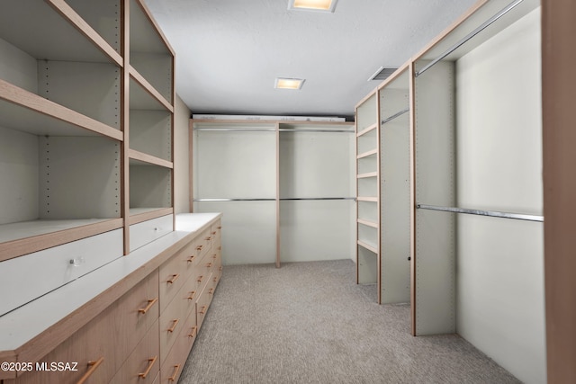 walk in closet with light colored carpet and visible vents