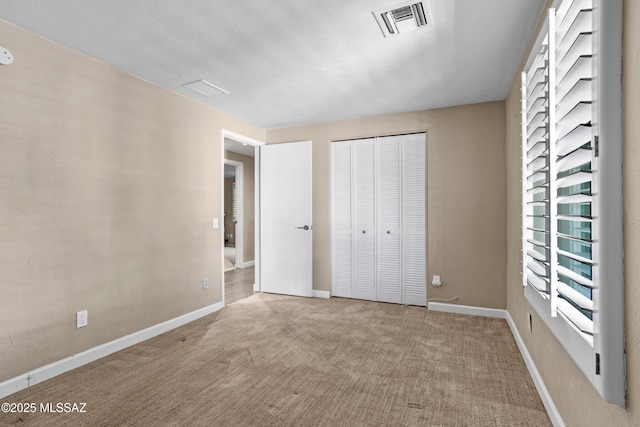 unfurnished bedroom featuring baseboards, visible vents, a closet, and carpet flooring