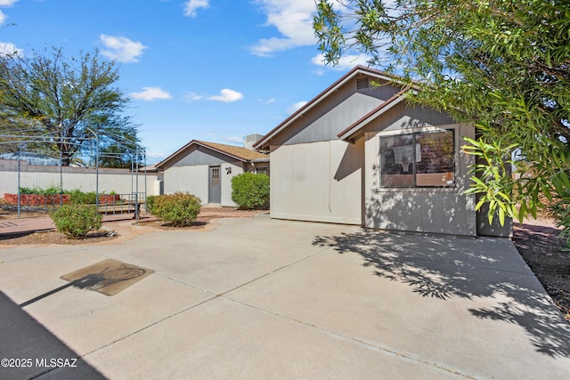 exterior space featuring fence, a patio, and an outbuilding