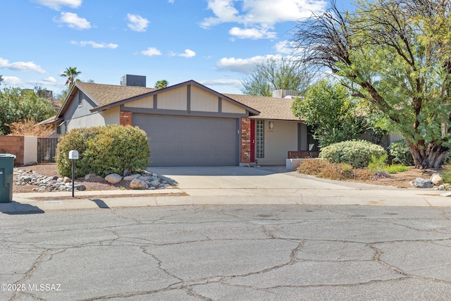 view of front of home featuring brick siding, a shingled roof, concrete driveway, an attached garage, and fence