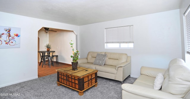 carpeted living room with ceiling fan