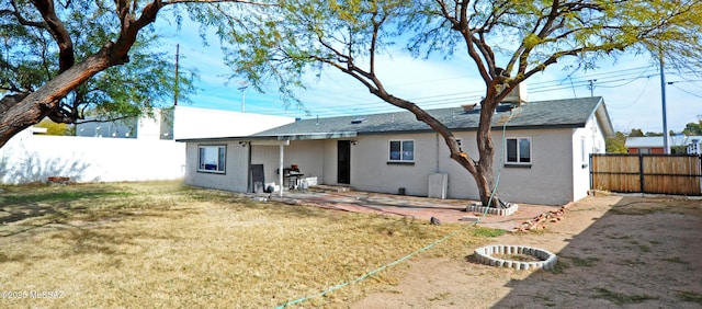 back of property with a lawn and a patio area