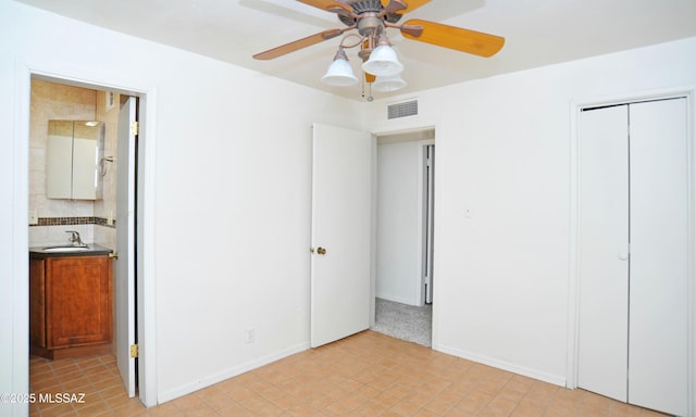 unfurnished bedroom with sink, ceiling fan, and ensuite bathroom