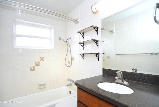 full bathroom featuring tiled shower / bath, vanity, and toilet