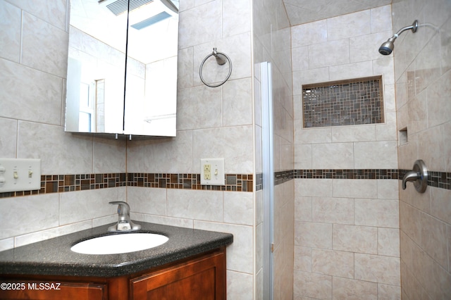 bathroom featuring a tile shower and vanity