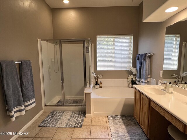 bathroom featuring plus walk in shower, a healthy amount of sunlight, tile patterned floors, and vanity