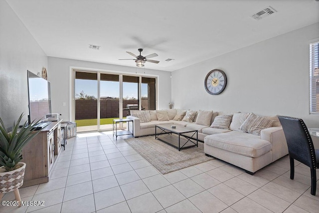 living room with light tile patterned floors, a healthy amount of sunlight, and ceiling fan