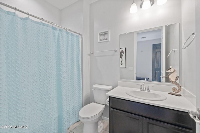 bathroom featuring vanity, tile patterned floors, toilet, and walk in shower