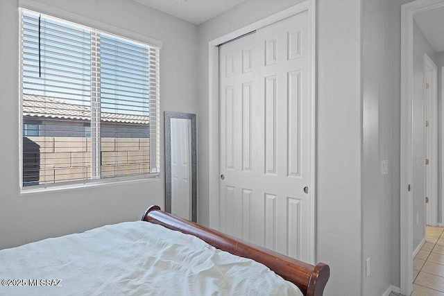 tiled bedroom with multiple windows and a closet