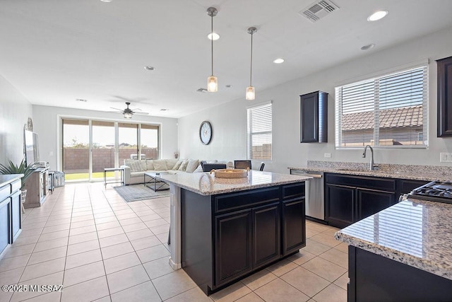 kitchen with light stone counters, decorative light fixtures, a center island, light tile patterned floors, and stainless steel dishwasher