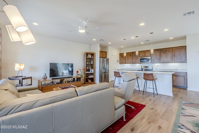 living room featuring ceiling fan and light wood-type flooring