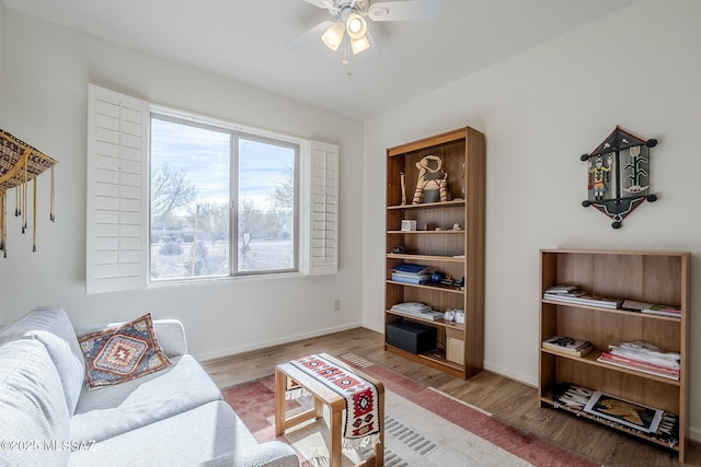 living room featuring wood-type flooring and ceiling fan