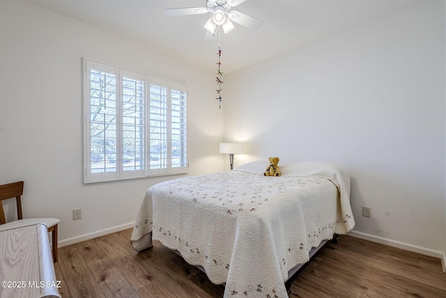 bedroom with dark hardwood / wood-style flooring and ceiling fan