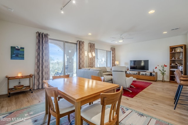 dining room featuring track lighting, light hardwood / wood-style floors, and ceiling fan