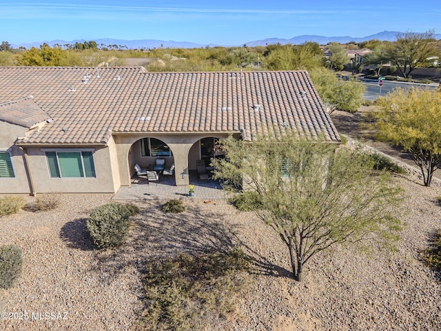 rear view of house with a mountain view and a patio area