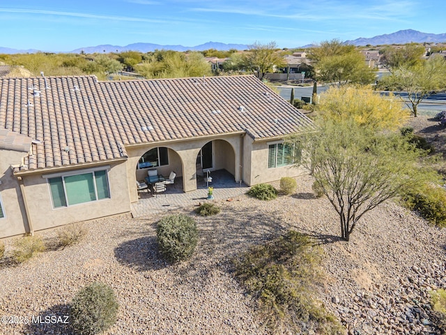 rear view of house featuring a mountain view and a patio area