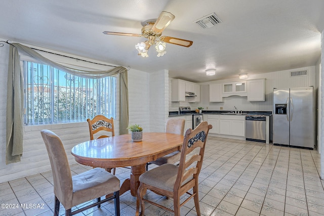 dining space featuring sink and ceiling fan