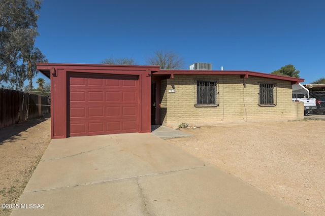 view of front of home featuring brick siding, concrete driveway, fence, and an attached garage