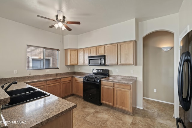 kitchen with ceiling fan, kitchen peninsula, sink, and black appliances