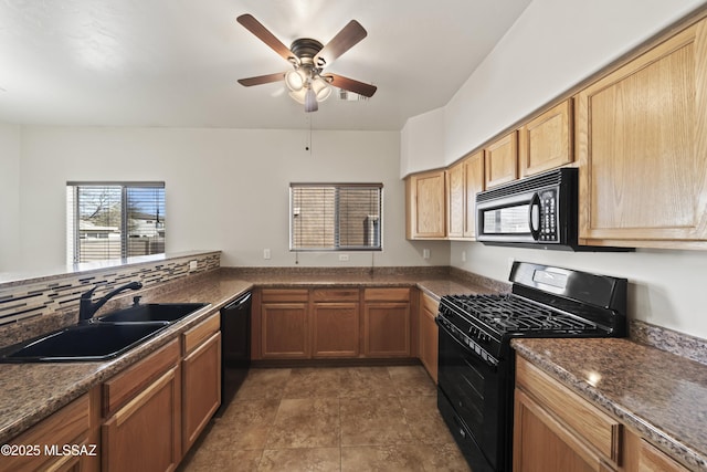 kitchen featuring sink, kitchen peninsula, ceiling fan, dark stone counters, and black appliances