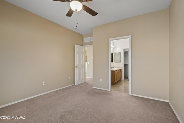 unfurnished bedroom featuring connected bathroom and light carpet