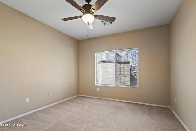 spare room featuring light colored carpet and ceiling fan