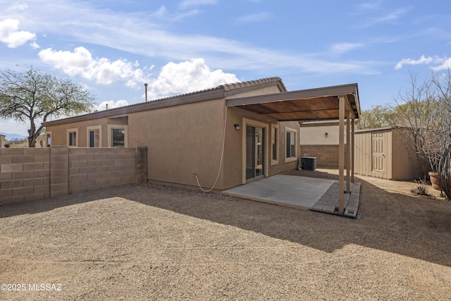 back of house with a storage shed, central AC unit, and a patio area