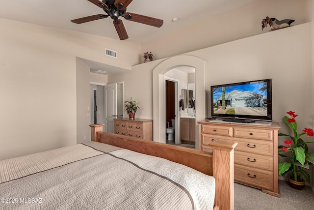 carpeted bedroom with ceiling fan, vaulted ceiling, and connected bathroom