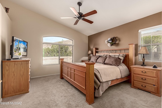 bedroom featuring ceiling fan, vaulted ceiling, multiple windows, and light carpet