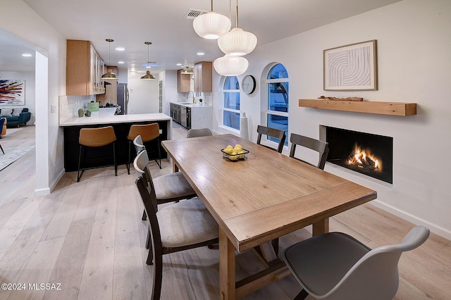 dining room with sink and light wood-type flooring