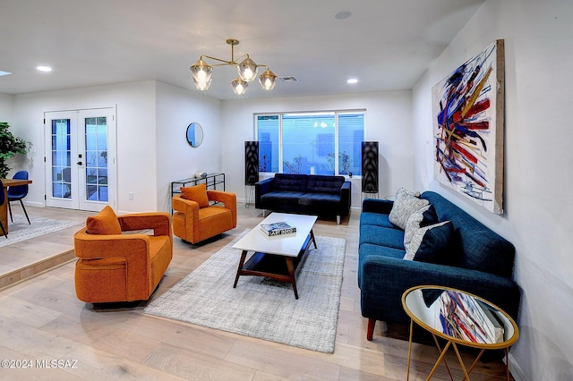 living room featuring a chandelier, french doors, and light wood-type flooring