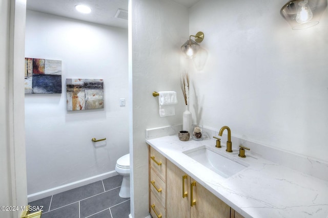 bathroom with toilet, tile patterned floors, and vanity