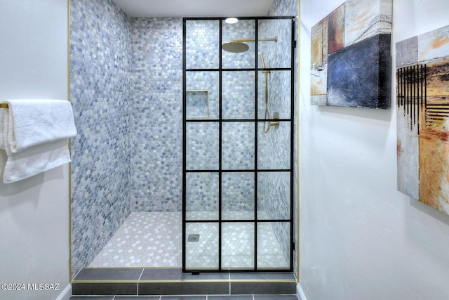 bathroom with tile patterned floors and a tile shower