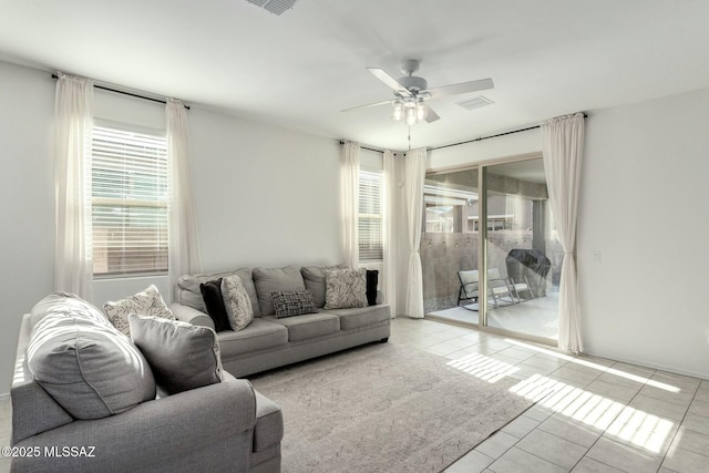 tiled living room featuring ceiling fan and plenty of natural light