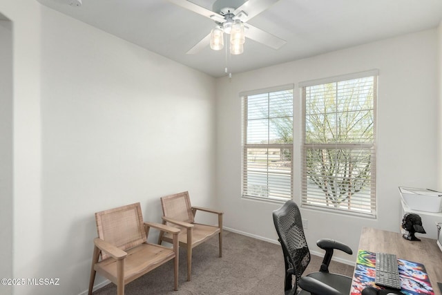 carpeted home office featuring ceiling fan