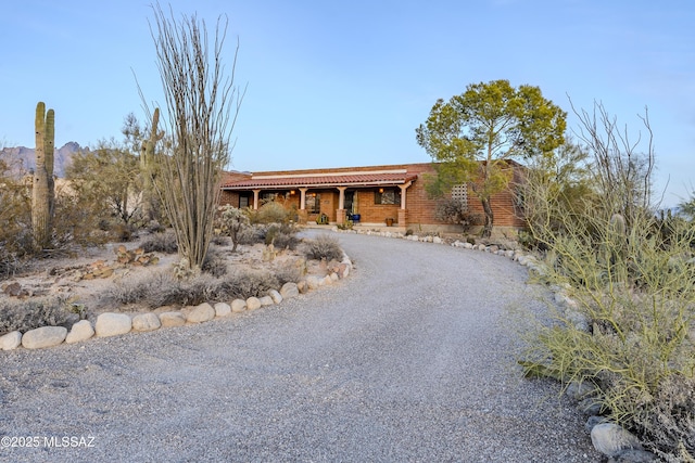 view of front of property with covered porch and gravel driveway