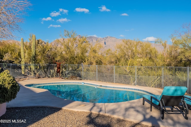 view of swimming pool with a patio, a mountain view, fence, and a fenced in pool