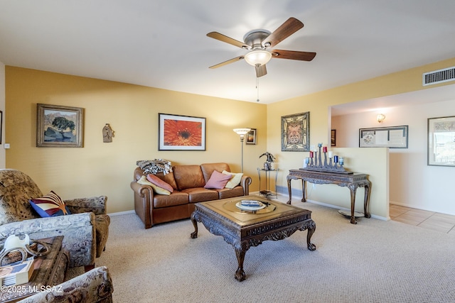 carpeted living area with tile patterned flooring, baseboards, visible vents, and ceiling fan