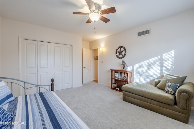 bedroom featuring a ceiling fan, carpet, visible vents, baseboards, and a closet