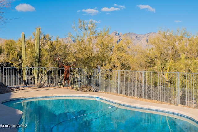 view of swimming pool with a fenced in pool, a mountain view, and fence