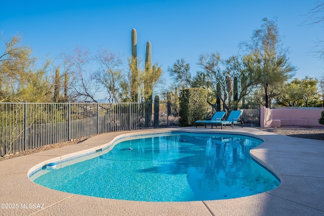 view of swimming pool featuring a patio area, a fenced in pool, and fence